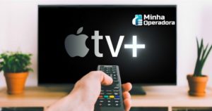 Imagem de uma pessoa apontando o controle para a TV com a logo da Apple TV