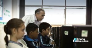 Alunos utilizando o computador com orientação do professor.